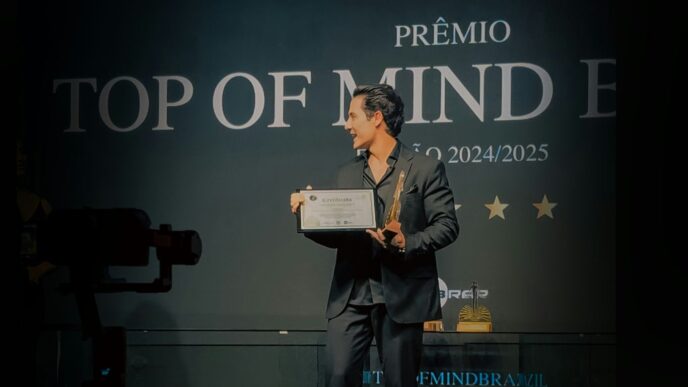 Man holding award on stage with "top of mind" sign