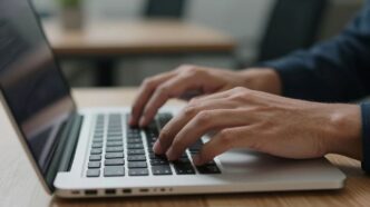 Hands typing on a laptop keyboard.
