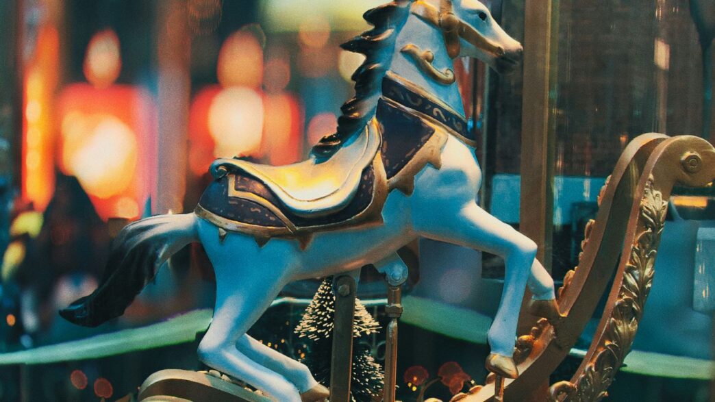 selective focus photo of blue horse carousel