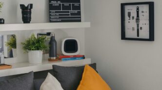 a living room with a gray couch and a white shelf