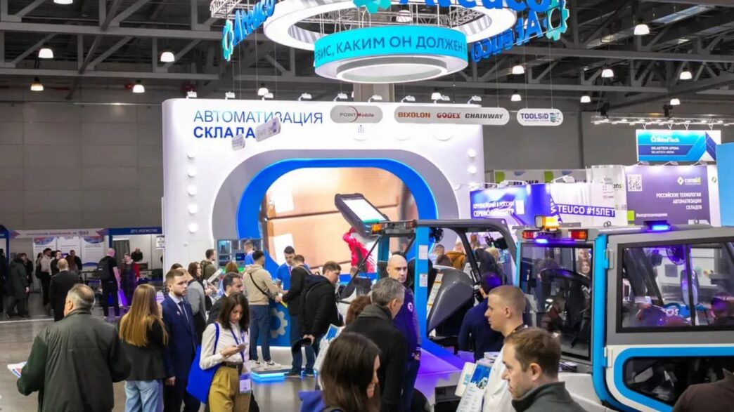 Crowd at an exhibition with booths and displays.