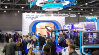 Crowd at an exhibition with booths and displays.