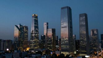 Modern cityscape at dusk, illuminated skyscrapers, venture capital firms.