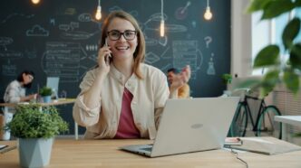 Smiling woman talking on phone in modern office.