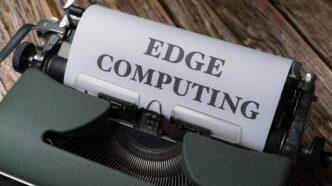 a close up of a typewriter with a paper reading edge computing
