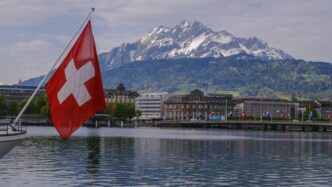 a swiss flag on a boat in the water