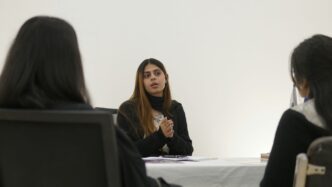 Woman speaking to two people across table