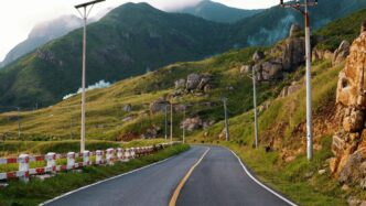 A winding road leads through a mountainous landscape.