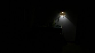 a dark room with a lamp on the wall