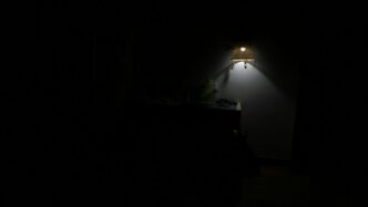 a dark room with a lamp on the wall