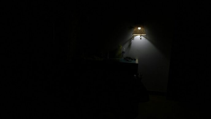 a dark room with a lamp on the wall