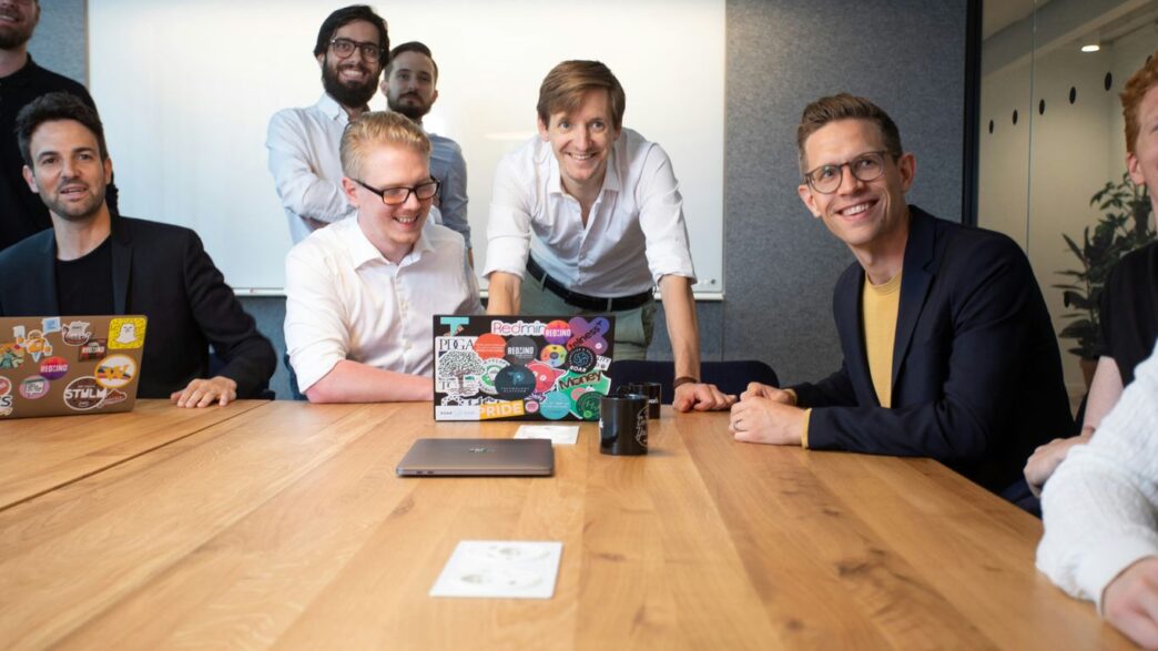 a group of people sitting around a wooden table