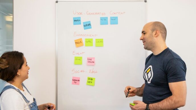 a man standing next to a woman in front of a whiteboard