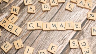 scrabble tiles spelling climate on a wooden surface