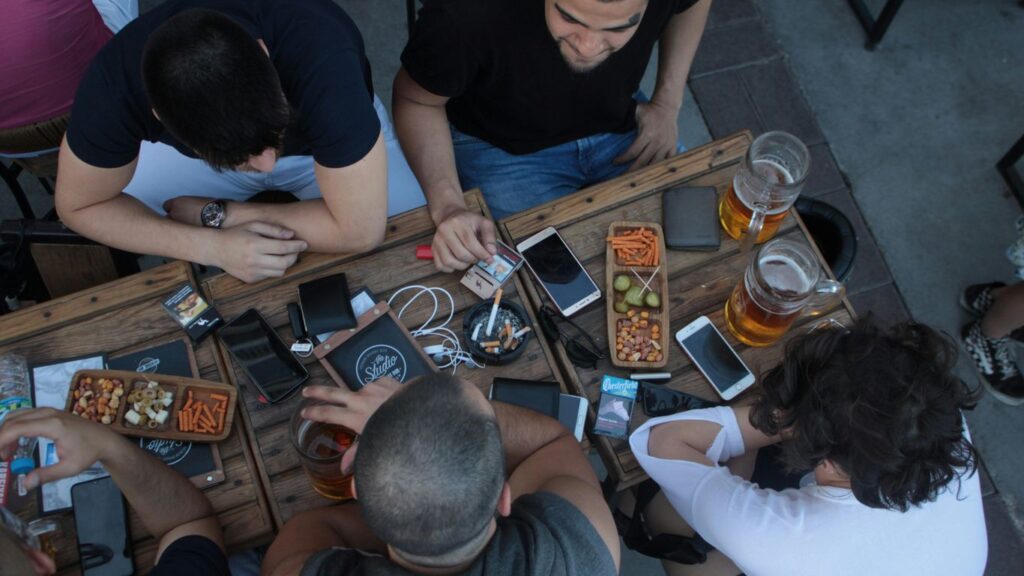 four men sitting on table while drinking