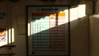 A timetable with sunlight casting a shadow.
