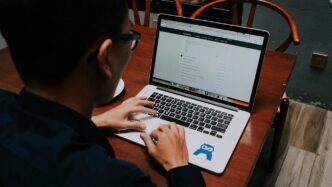 a man sitting at a table using a laptop computer