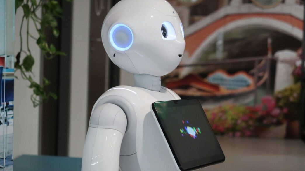 a white robot holding a tablet in its hand