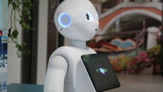 a white robot holding a tablet in its hand