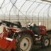 a red tractor is parked in a greenhouse