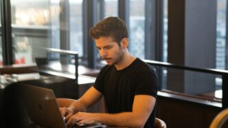 man in black crew neck t-shirt using macbook