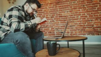 a man sitting on a couch using a laptop computer