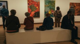 a group of people sitting on a bench in a museum