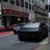 A black tesla cybertruck parked on a city street.