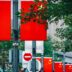 Chinese flags displayed on a street with trees.
