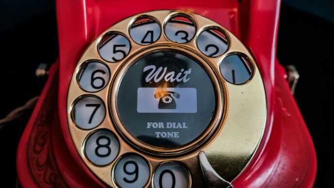 an old red rotary telephone with a dial on it