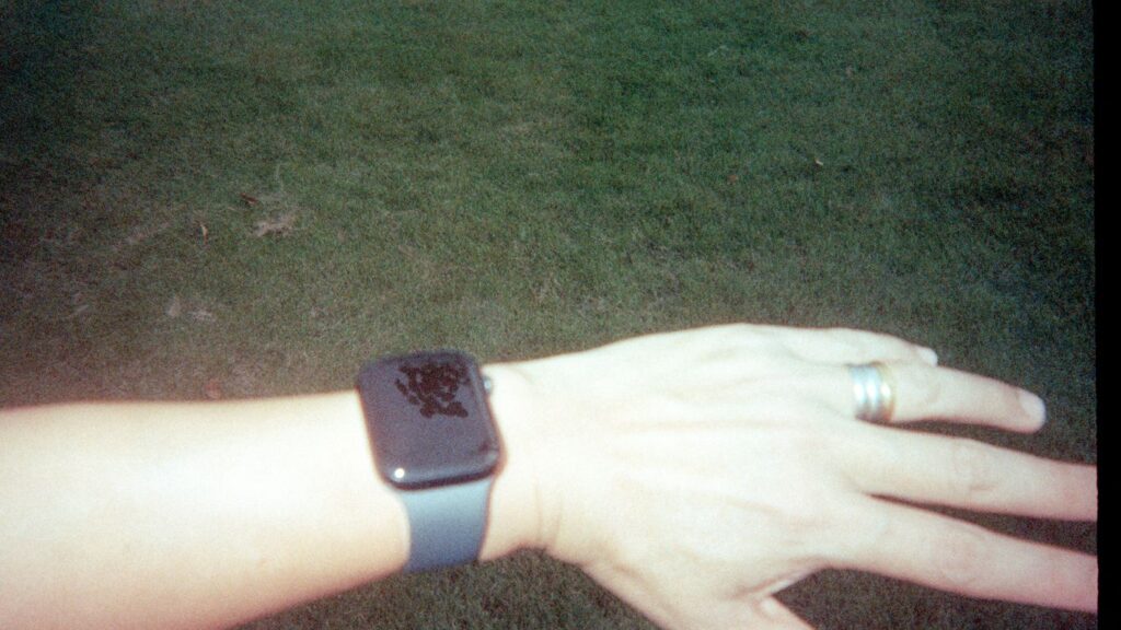 A wrist wearing a smartwatch with a dark screen.