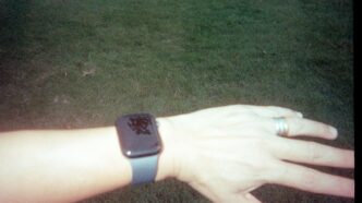 A wrist wearing a smartwatch with a dark screen.