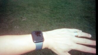 A wrist wearing a smartwatch with a dark screen.