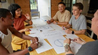 a group of people sitting around a wooden table
