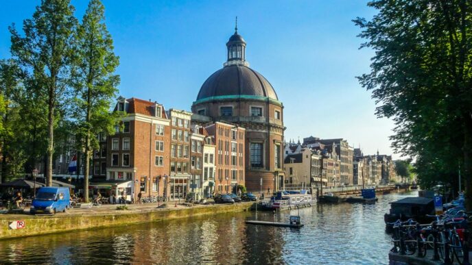 Canal in amsterdam with historic buildings and dome.