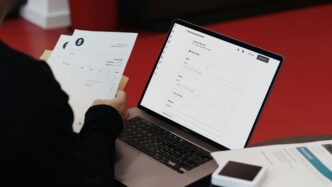A person sitting at a desk with a laptop and papers