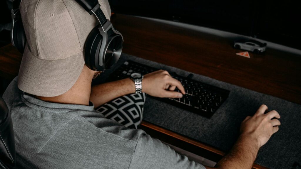 a man wearing headphones and sitting at a desk with a computer