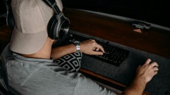 a man wearing headphones and sitting at a desk with a computer