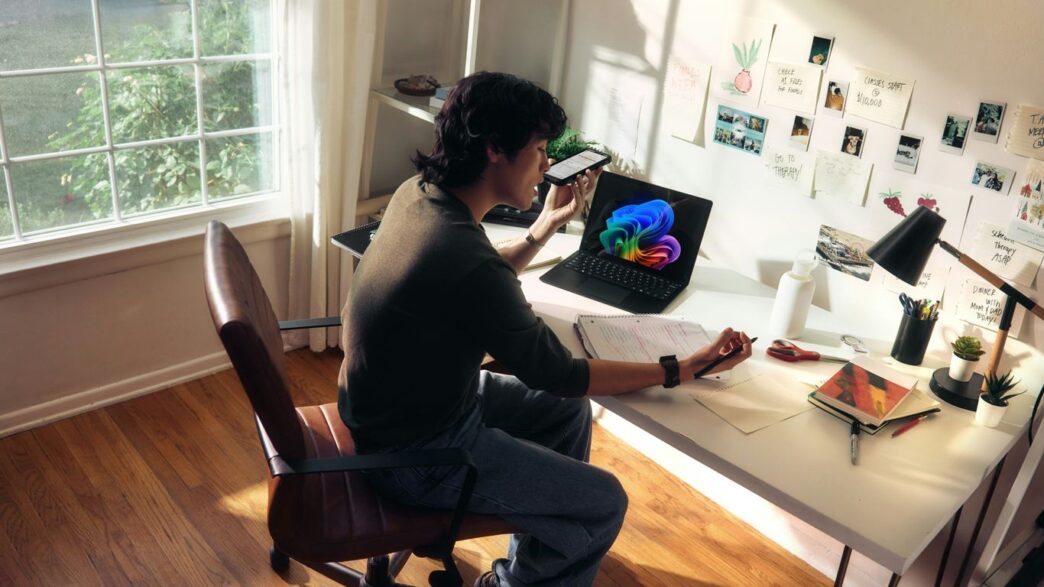 Person working at a desk with a laptop and books.