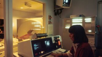 a woman sitting in front of a laptop computer