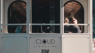 People ride on a trolley car in the city.