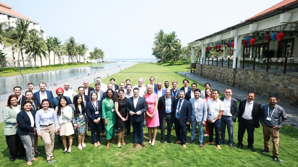 A diverse group of people posing for a photo outdoors.