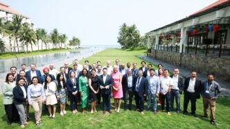 A diverse group of people posing for a photo outdoors.