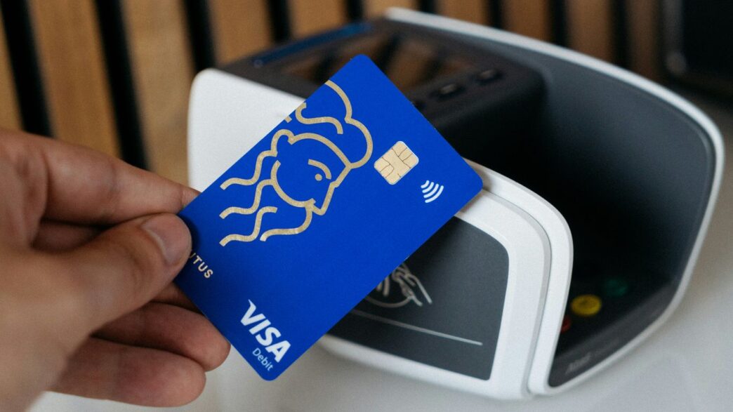 a person is holding a blue credit card
