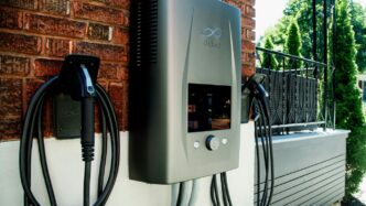 Electric car charging station mounted on brick wall