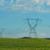 a field with power lines in the distance