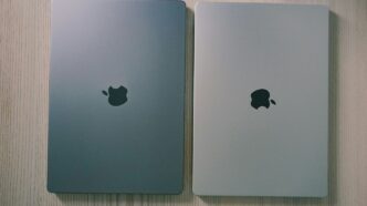 two silver ipads side by side on a wooden surface