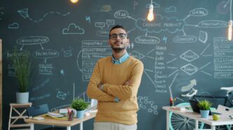 Man standing with arms crossed in front of chalkboard.