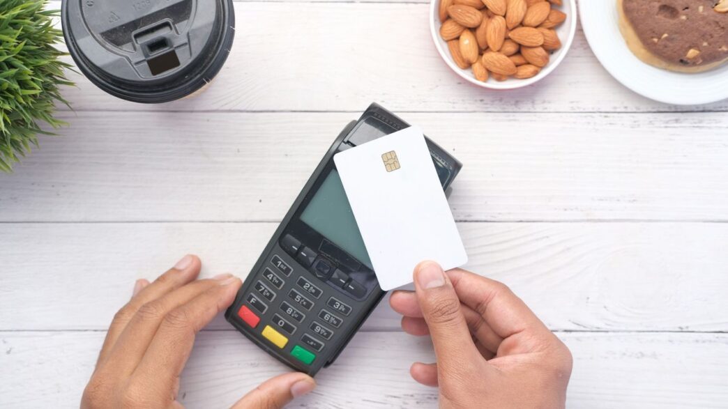 a person holding a credit card next to a calculator