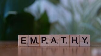 A wooden block spelling the word empathhy on a table